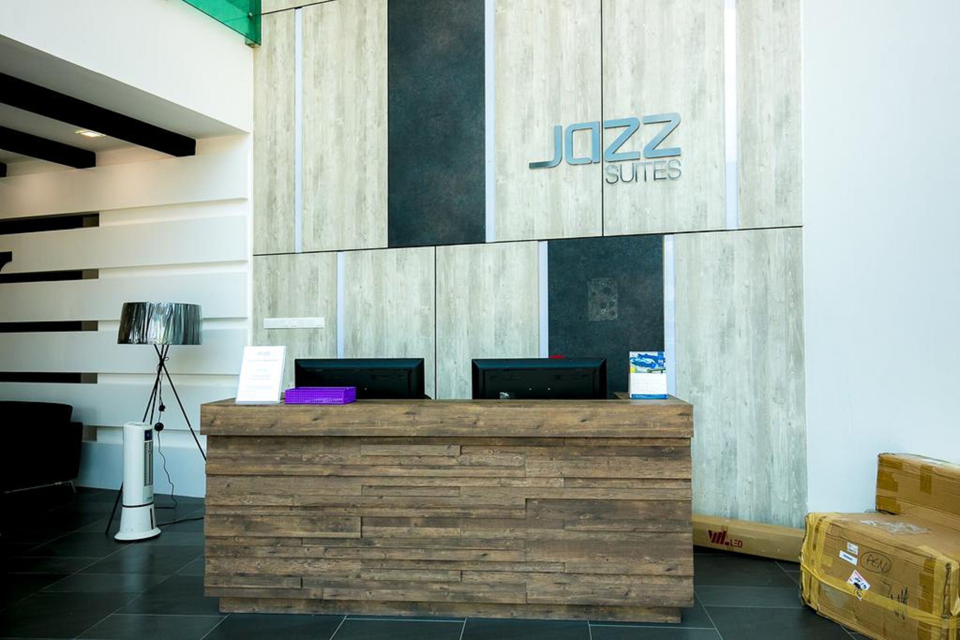 A reception desk with a wooden finish and a sign reading "JAZZ SUITES".