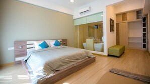 Een moderne slaapkamer met een bed, een kaptafel en een inloopkast.