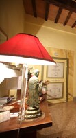 Una stanza con soffitto in legno, una lampada rossa, una statua e quadri appesi al muro.