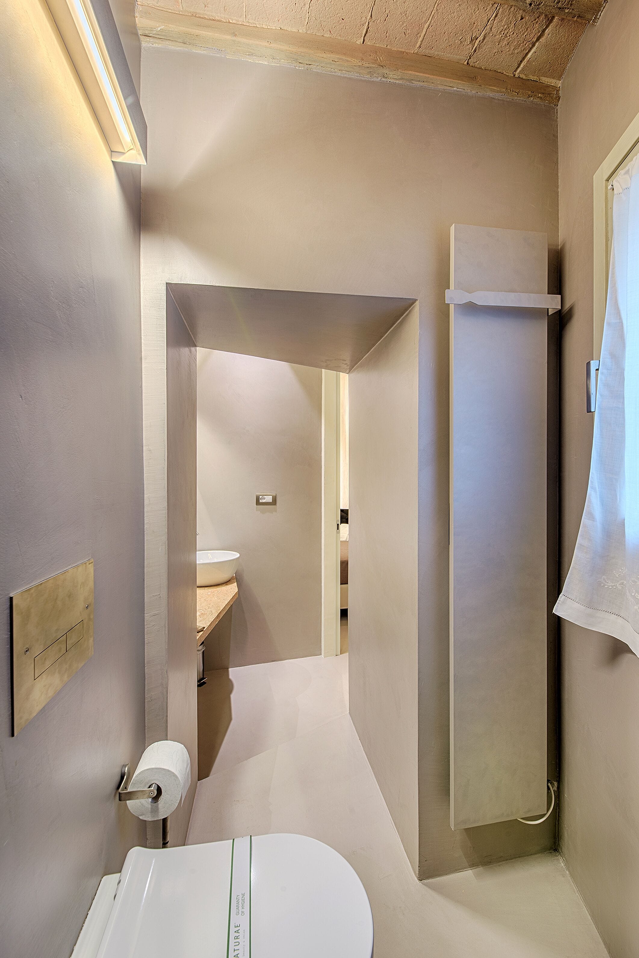 A modern bathroom with a toilet, a sink, and a shower.