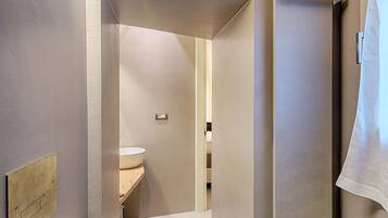 A modern bathroom with a toilet, a sink, and a shower.