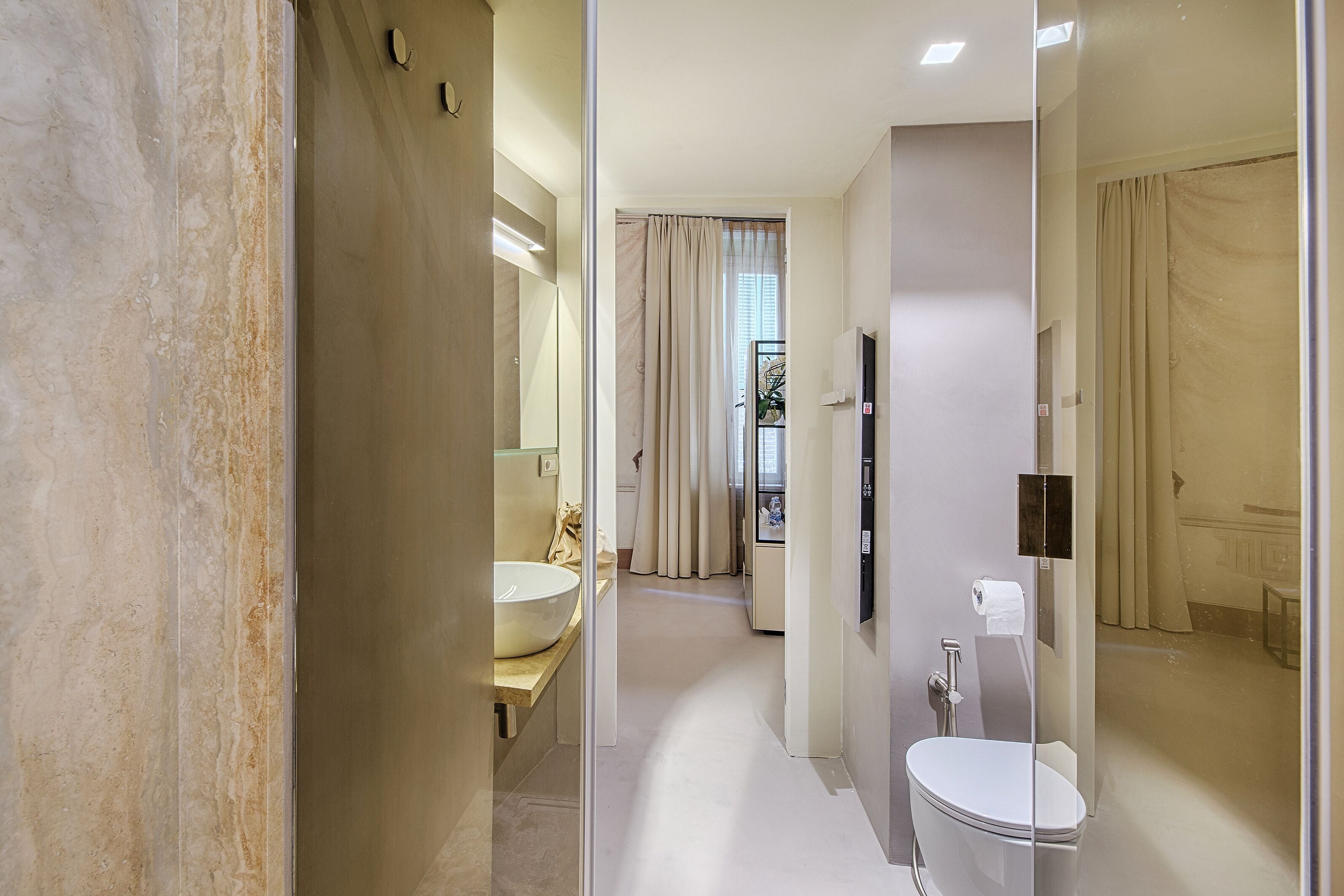 Ein modernes Badezimmer mit einem großen Spiegel, einem Waschbecken und einer Toilette.