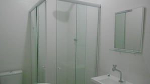 A bathroom with a glass shower enclosure, a white sink, and a mirror. - Gohouse - Riachuelo 306 B (Rio de Janeiro)