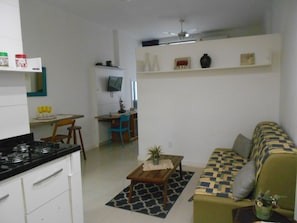 A compact living space with a kitchenette, a dining area, and a seating area with a sofa and a small table. - Gohouse - Piragibe 203 (Rio de Janeiro)