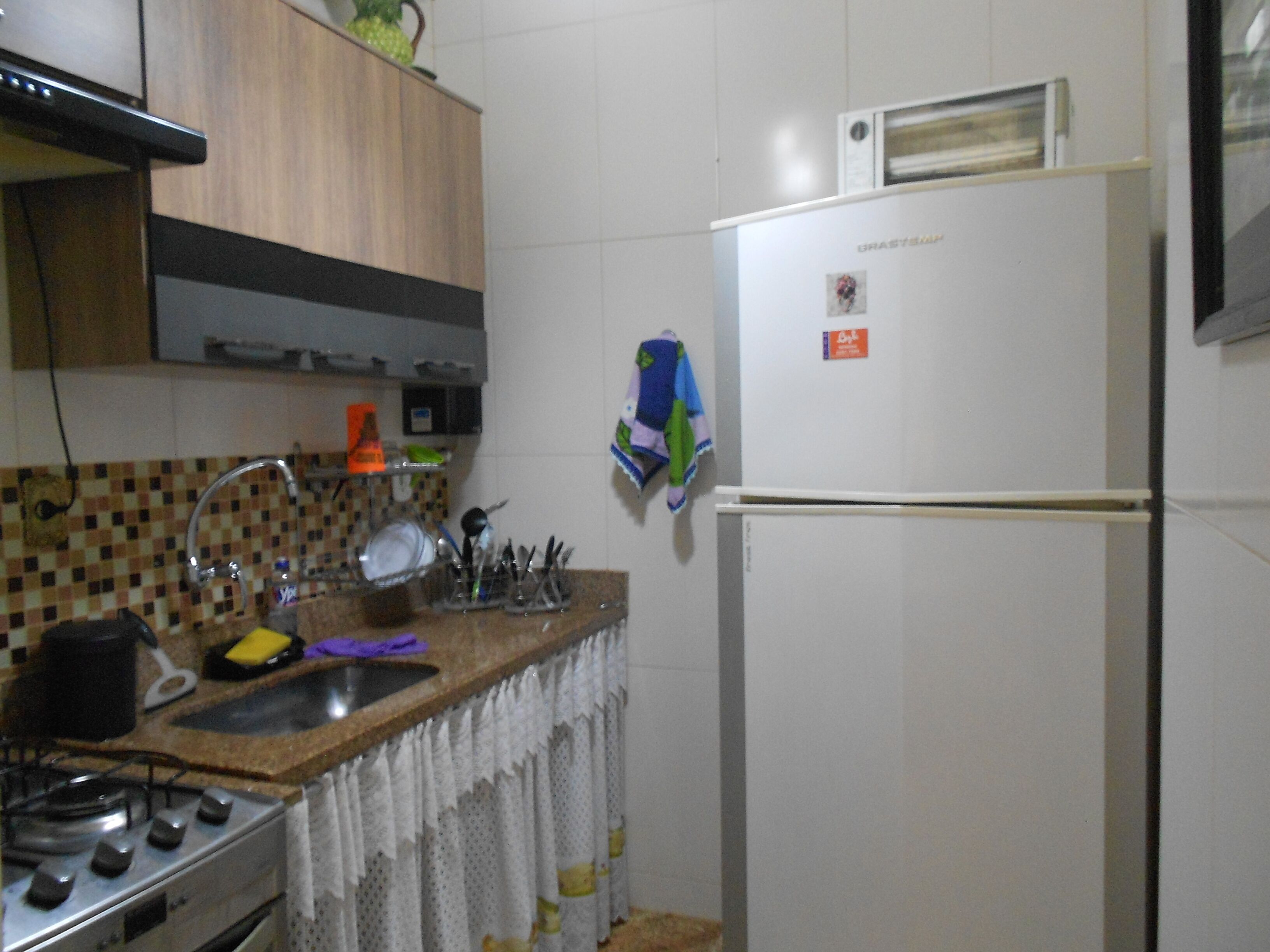 A kitchen with a stove, sink, and refrigerator.