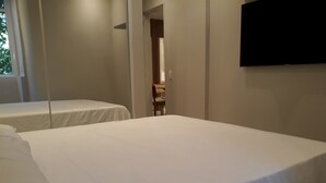 A hotel room with two single beds, a flat-screen TV mounted on the wall, and a window with curtains. - Gohouse - Ataulfo 201 (Rio de Janeiro)