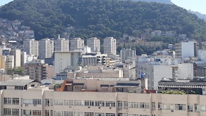 A cityscape with a prominent mountain in the background and a mix of residential and commercial buildings in the foreground. - Gohouse - Siqueira 1417 (Rio de Janeiro)