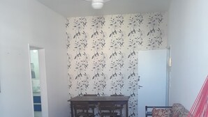 Une pièce comprenant une table à manger, des chaises, un canapé, un hamac et un ventilateur de plafond.