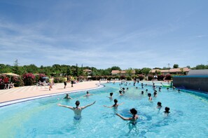 A swimming pool with people swimming and relaxing.