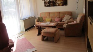 A living room with a sofa, armchairs, a coffee table, and a painting on the wall. - Holiday house without everyday noise (Altomünster)