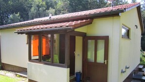 A small, single-story building with a tiled roof, a front door, and a window. - Holiday house without everyday noise (Altomünster)