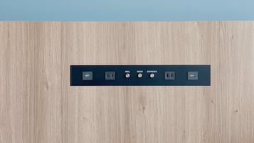A wall-mounted control panel with labeled switches for 'WALL,' 'ROOM,' and 'ENTRANCE' along with USB and power outlets.