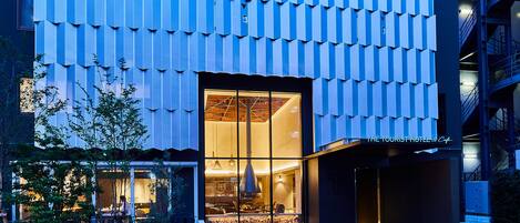 A modern hotel with a unique exterior featuring a patterned facade and a well-lit entrance.