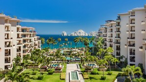 Een resort met meerdere gebouwen, een zwembad in het midden en uitzicht op de oceaan.