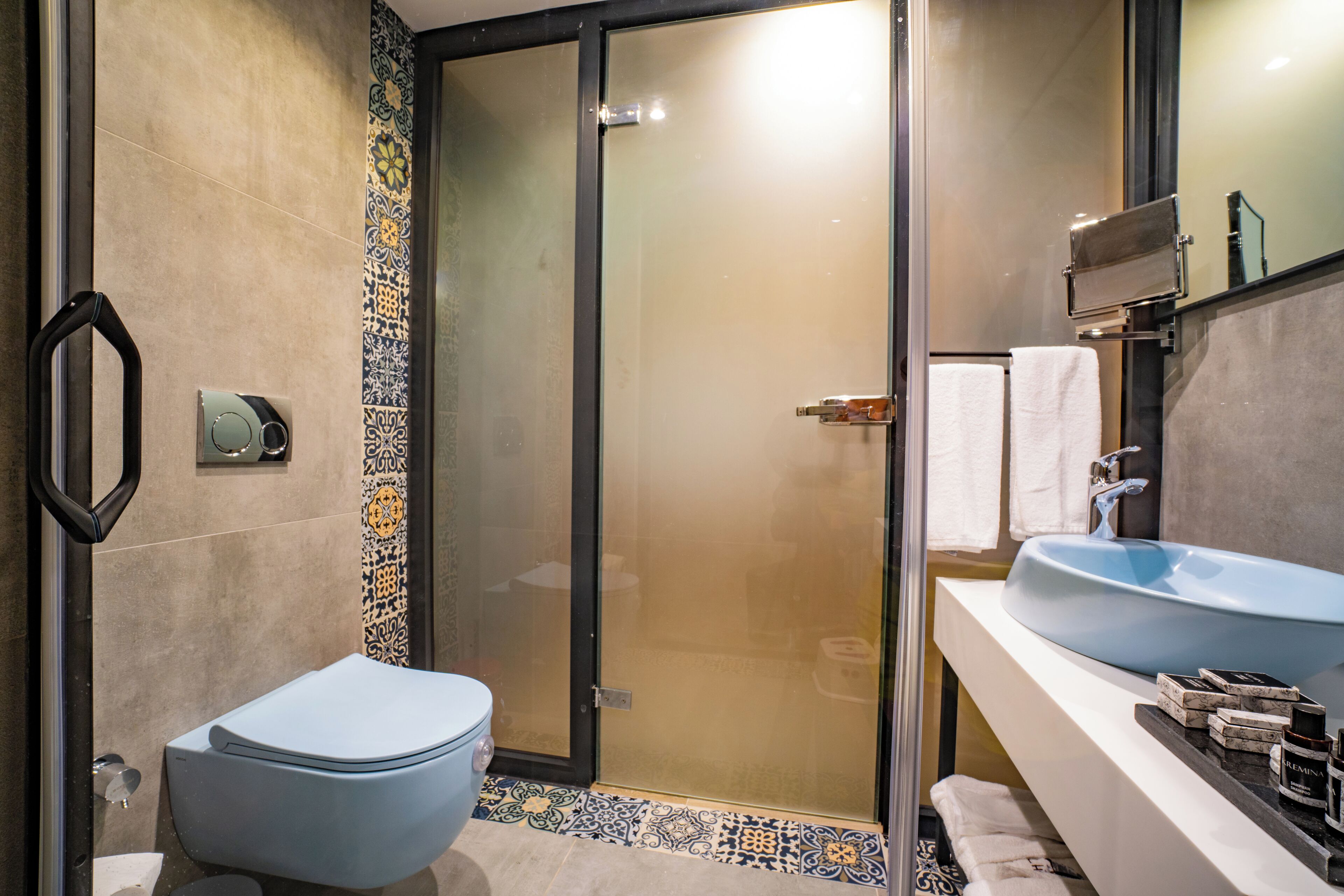 A modern bathroom with a toilet, shower, and sink.
