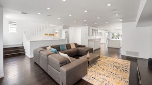 A spacious living room with a sectional sofa, a coffee table, and a patterned rug.
