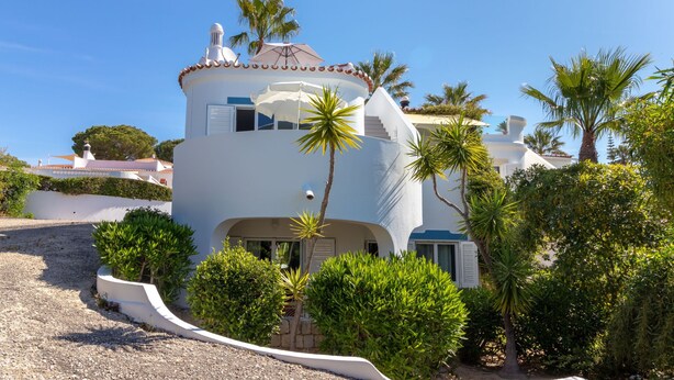 Un edificio blanco, de forma curva, con una cúpula y una escalera que lleva a la entrada.