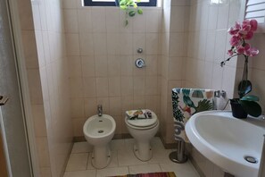 Een douche, een haardroger, een bidet, handdoeken