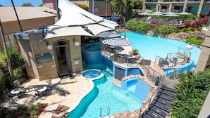 Área de piscina no terraço com hidromassagem, espreguiçadeiras e guarda-sóis.