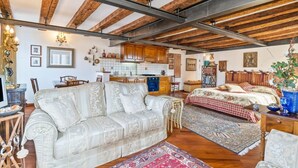 A spacious living area with a sofa, a dining table, and a kitchen in the background. - GuestHost - Exclusive studio perfect for 2 people and furnished in typical Venetian style overlooking the Canareggio Canal and Palazzo Labia. Location is strategic and convenient for those arriving in Venice: about 5 minutes walk from the train station a (Venezia)