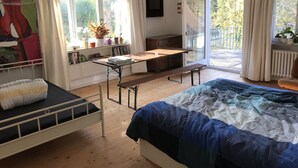 A bedroom with a bed, a desk, and a bench. There is a window with curtains, a radiator, and a plant on the windowsill. - VILLA in VELDEN (Velden)