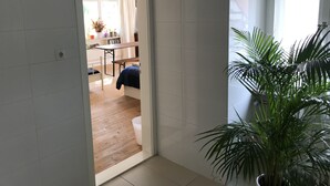 A doorway leading to a room with a wooden floor, a bed, and a window with curtains. - VILLA in VELDEN (Velden)