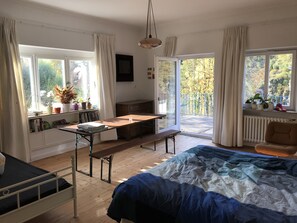 A bedroom with a bed, a desk, a chair, and a view of the outdoors through large windows. - VILLA in VELDEN (Velden)