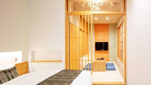 Une chambre d’hôtel moderne équipée d’un lit, d’une télévision et d’une cloison en bois ornée d’un motif décoratif.