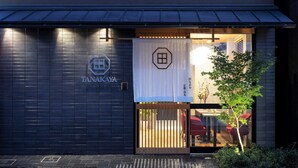 Un bâtiment à la façade sombre, avec un logo bien visible et une enseigne portant des caractères japonais.