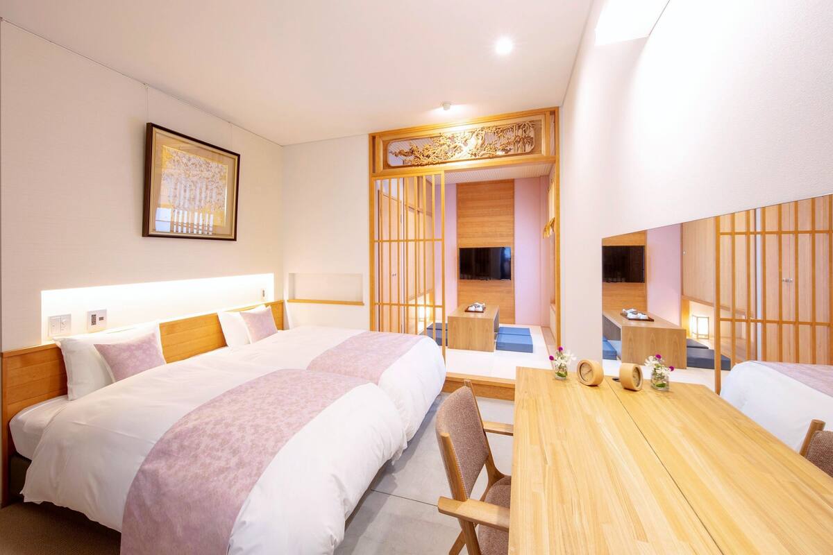 Une chambre d’hôtel avec un grand lit, une table en bois et un téléviseur.