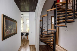 Una escalera con detalles de madera y cadenas metálicas, que conduce a un piso superior.