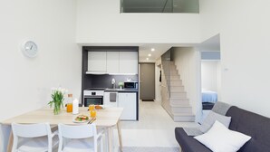 A modern apartment with a dining area, kitchen, and living room. - Spot Apartments Airport (Vantaa)