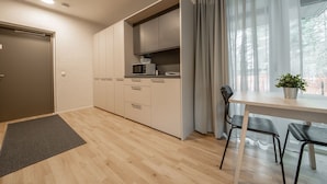 Una cucina moderna con mobili a incasso, un forno a microonde e un'area pranzo con tavolo e sedie.