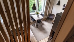 Una cucina moderna con zona pranzo, ampie finestre e vista sul verde.