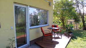 A patio with a sliding glass door, a small table, and a chair. - Stollis FeWo (Bensheim)
