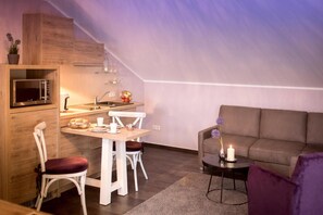 A compact living space with a kitchenette, a dining area, and a seating area. - Hotel Birkenhof (Bad Soden-Salmuenster)