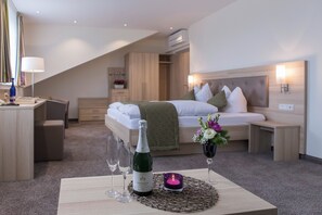 Ein modernes Hotelzimmer mit Bett, Nachttisch und Schreibtisch mit Lampe.