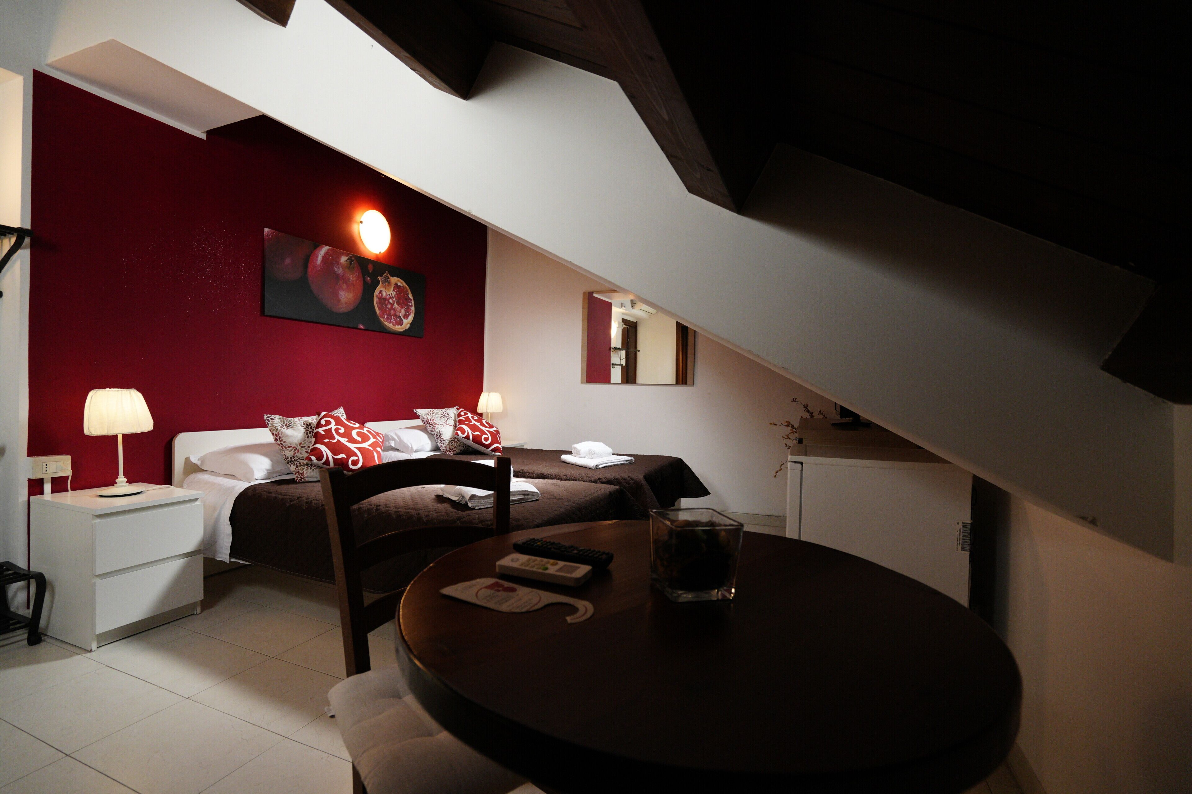 Une chambre à coucher avec un lit, une table de chevet, une lampe et un verre d’eau posé sur une table ronde.