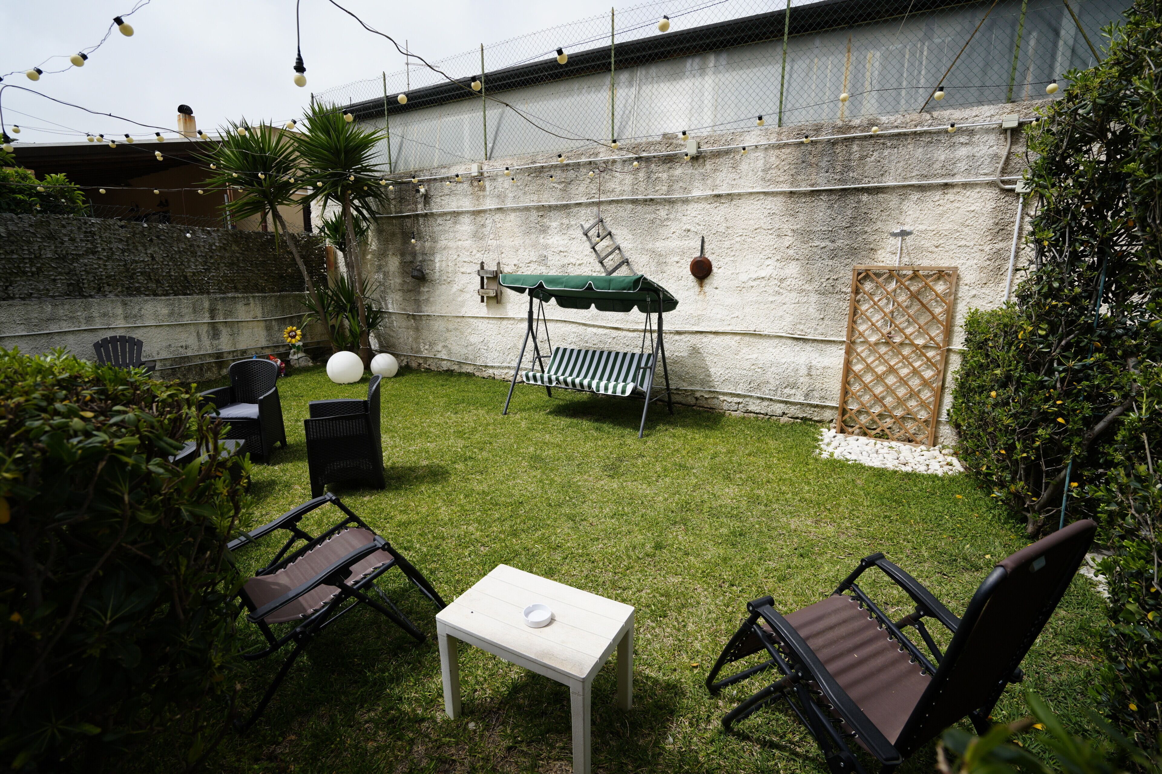 A patio with outdoor furniture, a table, and a swing set.