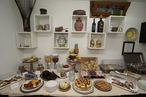 A buffet table with various food items and a display of decorative items on shelves.