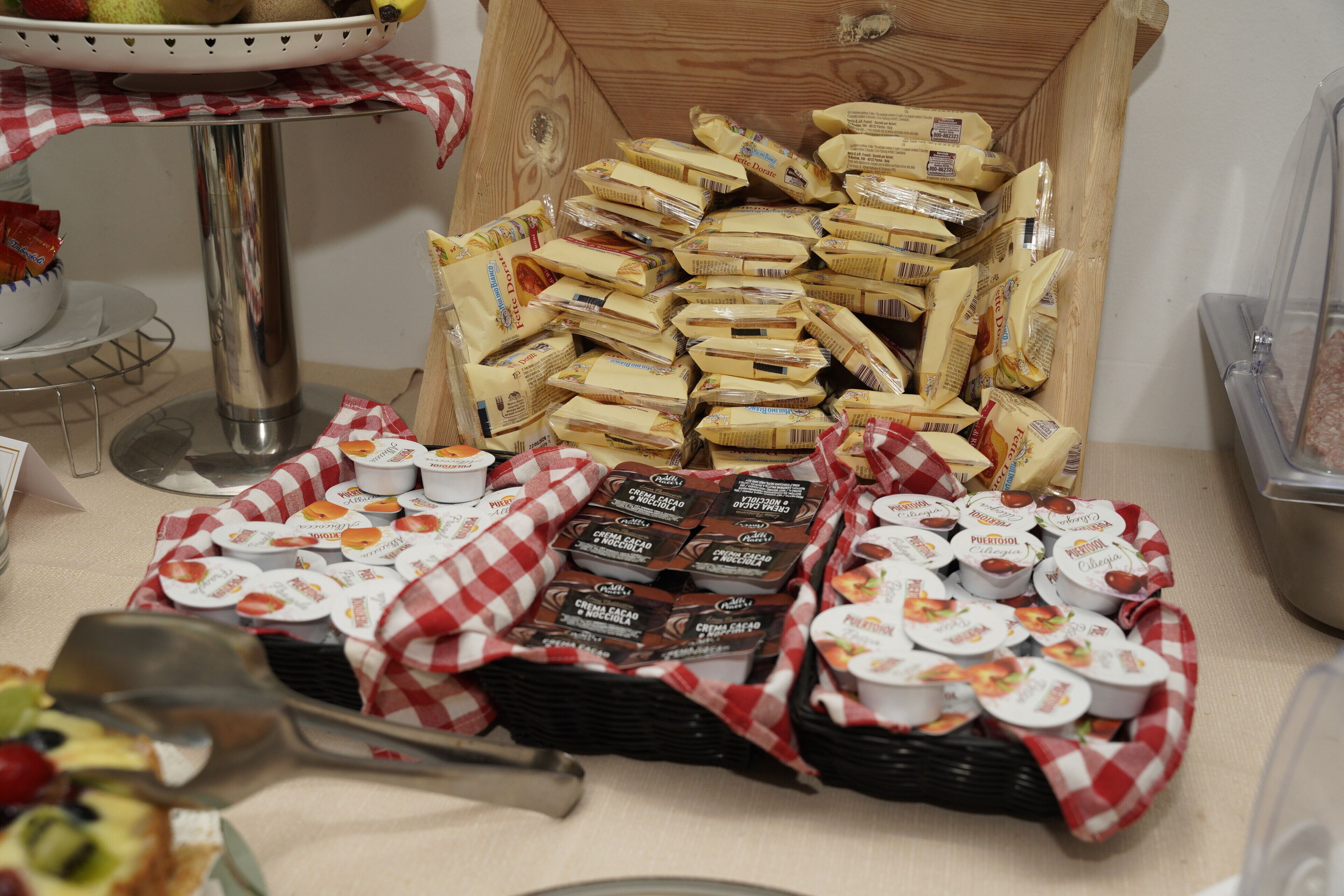A buffet table with various food items, including chocolate-covered snacks and yogurt cups, arranged on a checkered tablecloth.