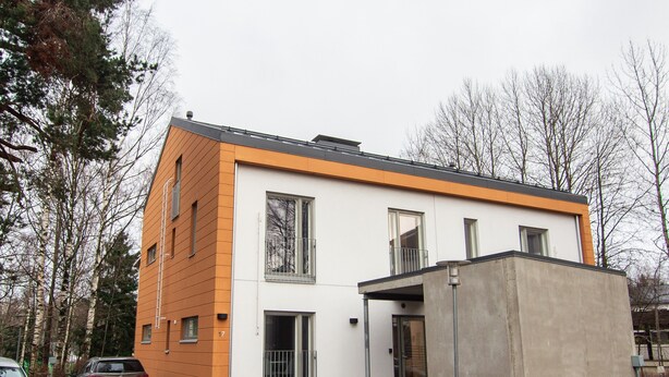 A modern two-story house with a garage, a covered porch, and a small concrete structure to the right. - Spot Apartments Helsinki (Helsinki)