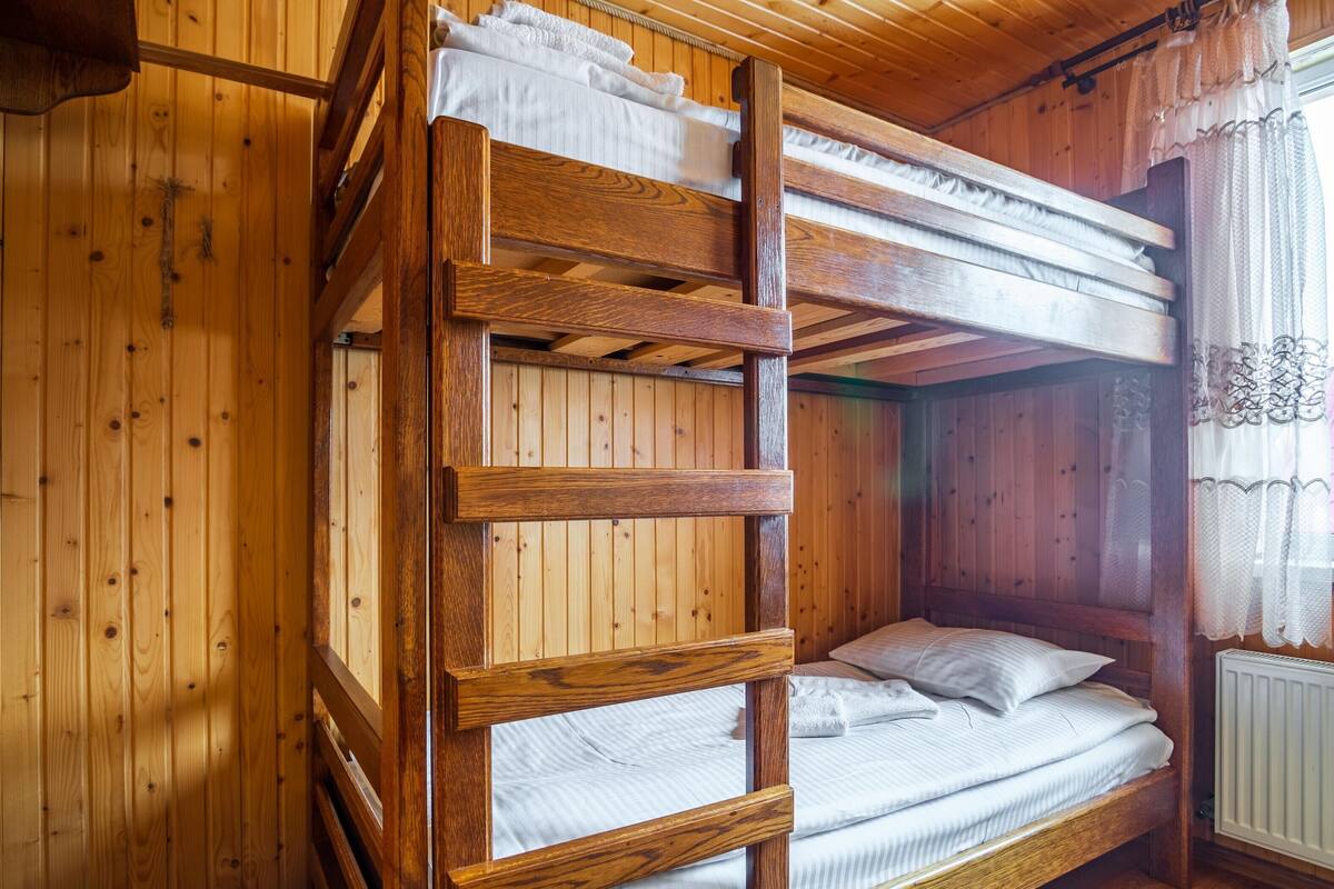 Ein Etagenbett mit Holleisten und einer weißen Matratze.
