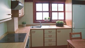 Eine kleine Küche mit Fenster, Spüle und Essbereich.