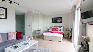 Ein modernes Hotelzimmer mit Bett, einer Couch, einem Couchtisch und einem großen Fenster.