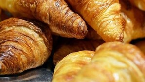 A close-up of golden-brown croissants piled together. - Affreschi Al Vaticano (Rome)