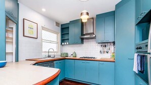 A modern kitchen with teal cabinets, a wooden countertop, and a gas stove. - 3 Funky &Cool Family Coolbinia 2BR for 4 (Coolbinia)