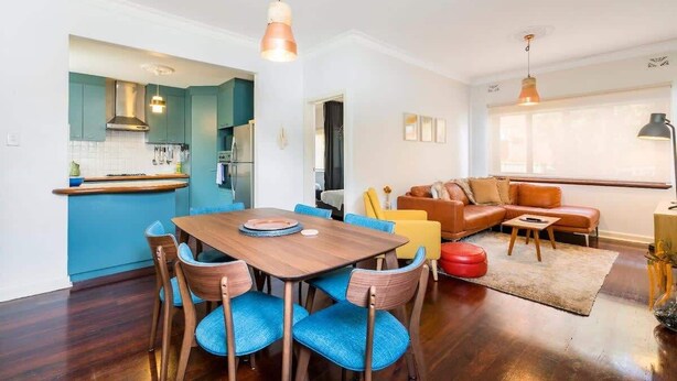 A modern kitchen with a dining area, a living room with a sofa and a coffee table, and a large window providing natural light. - 3 Funky &Cool Family Coolbinia 2BR for 4 (Coolbinia)