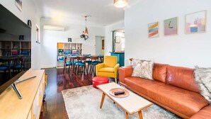 A spacious living area with a leather sofa, a wooden coffee table, and a dining area with chairs and a table. - 3 Funky &Cool Family Coolbinia 2BR for 4 (Coolbinia)