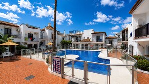 A hotel with a swimming pool, outdoor seating, and a clear blue sky. - AP327 - Casa Pico (Nerja)